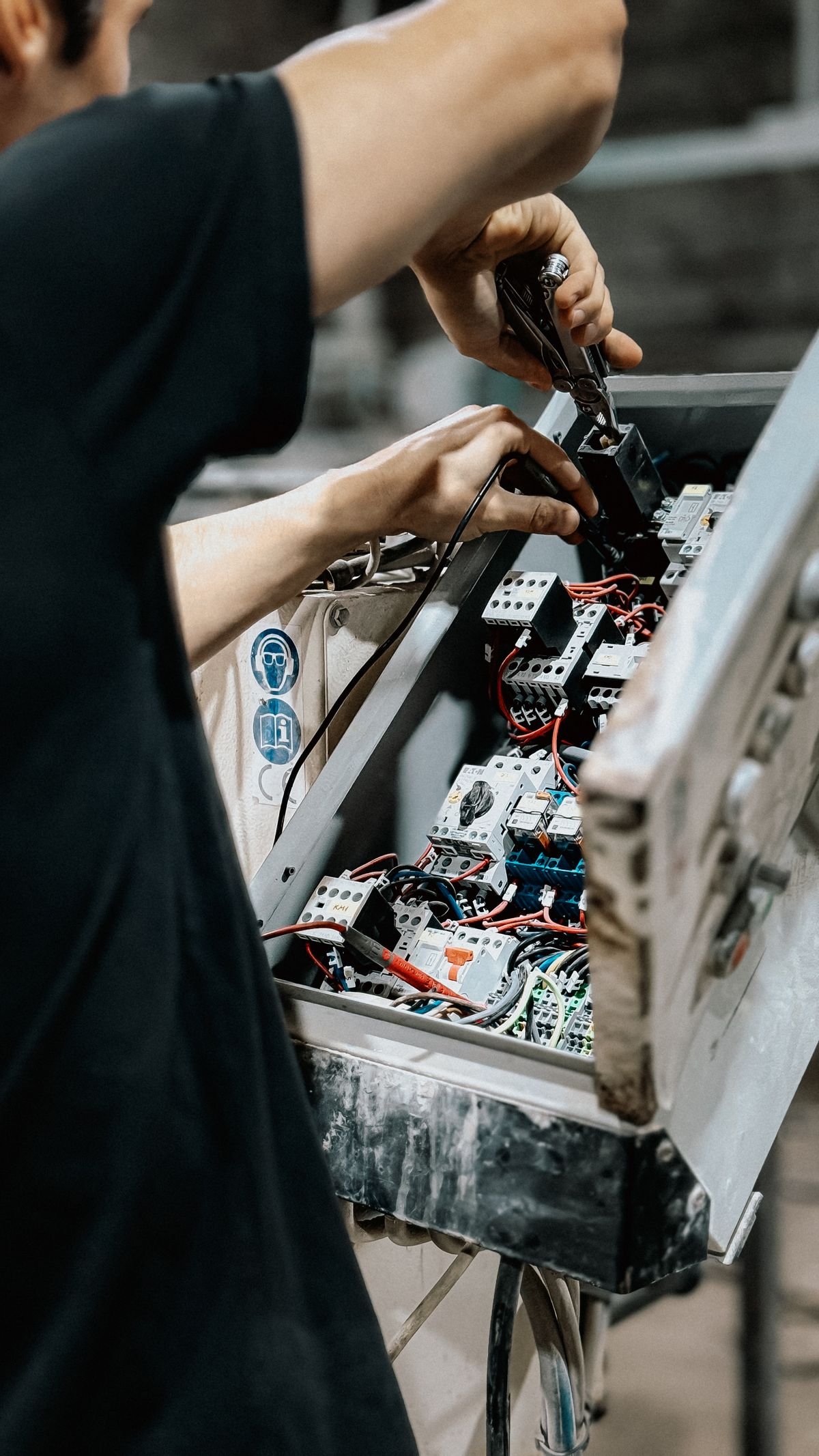 Hands carrying out electrical equipment maintenance